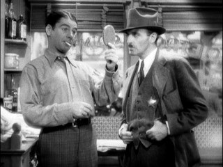 Tony (Paul Muni) and Inspector Guarino (C. Henry Gordon) hold each other in mutual contempt.