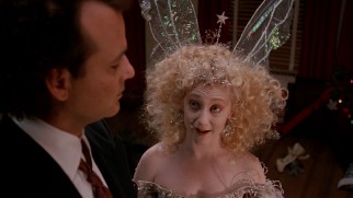 Frank is hit with knowledge and a toaster by the winged, violent Ghost of Christmas Present (Carol Kane).