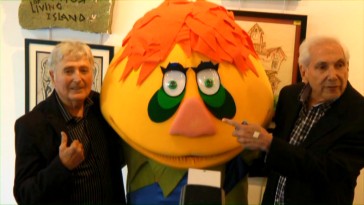 Sid (left) and Marty Krofft pose for photos with H.R. Pufnstuf between them at a 2010 Los Angeles event documented here.