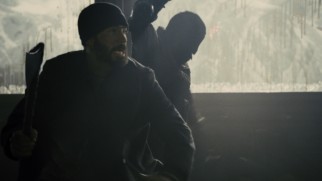 Curtis (Chris Evans) leads the charge against a car full of masked ax men.