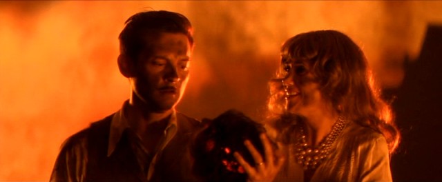 Devon Morehouse (Tobey Maguire) clutches the severed head of his mannequin wife as his mansion goes up in flames to the evident pleasure of his sister Cynthia (Kristen Wiig).