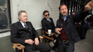 A denim-clad Fisher Stevens directs suited, seated Christopher Walken and Al Pacino on the set of "Stand Up Guys."