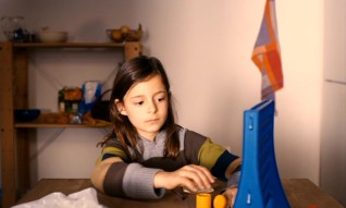 Clara (Mia Kasalo) plays a game of Connect Four.
