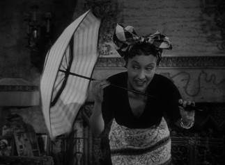 Norma Desmond (Gloria Swanson) performs a comedy routine with blinking eyes and a twirling umbrella for her young houseguest.