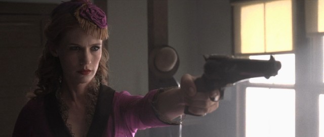 Sarah Ramirez (January Jones) wields a gun in her spiffy new purple dress in the 2013 western "Sweetwater."