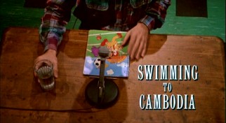 As this title shot illustrates, the production budget for "Swimming to Cambodia" covered such extravagant expenses as a glass of water, a microphone, a Ronald McDonald notebook, and a desk.