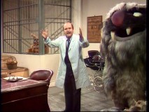 Dom DeLuise is surrounded by monsters at an animal institution.