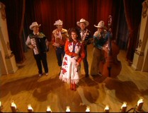 You know, I didn't take these grown men in cowboy suits seriously until they were joined on stage by an eerily flirty cowgirl with unexpectedly large hair.