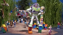 Buzz Lightyear towers over theme park guests in the scale model of Toy Story Land.