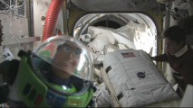 In "Buzz Lightyear Mission Logs", America's favorite space ranger poses for the camera onboard the NASA shuttle as astronauts pull out their suits.