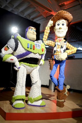 Much larger than life statues of buddies Buzz Lightyear and Woody constructed from Lego pieces stand proudly.