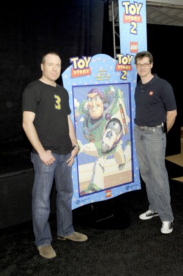 Toy Story 1 & 2 story artist Jason Katz and Lego master builder Erik Varszegi pose by a completed Buzz Lightyear section of the Lego mural.