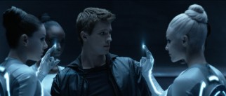 Sam Flynn (Garrett Hedlund) gets a welcome from four Sirens, who strip his clothes with their lighted fingers to dress him in the fashion of the alternate world.