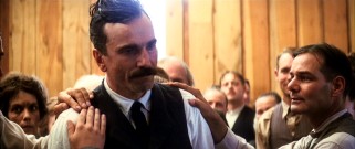 Hands flock to the shoulders of Daniel Plainview after his intense baptism at the Church of the Third Revelation.