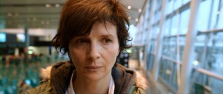 As Becca (Juliette Binoche) rides up an escalator, her spirits remain low.