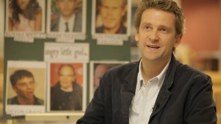 Director Daniel Stamm speaks in front of cast headshots in "The Making of '13 Sins.'"