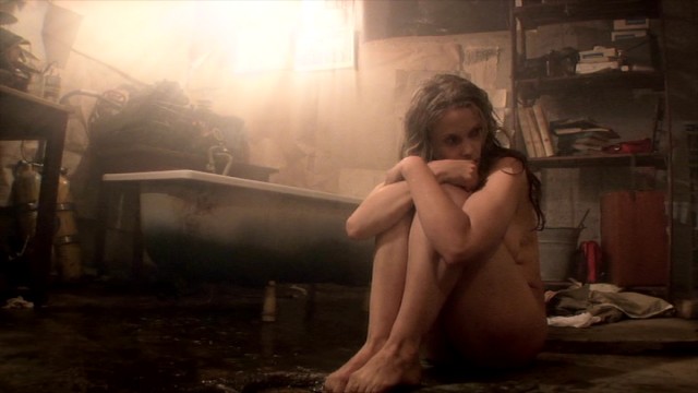 The tailless present-day Thale (Silje Reinåmo) curls up in a fetal position next to her milky bathtub.