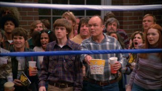 Father (Kurtwood Smith) and son (Topher Grace) enjoy a wrestling match together ringside.