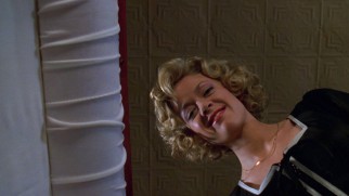 Big sister Laurie (Lisa Robin Kelly) gives a smiling farewell at her grandmother's coffin.