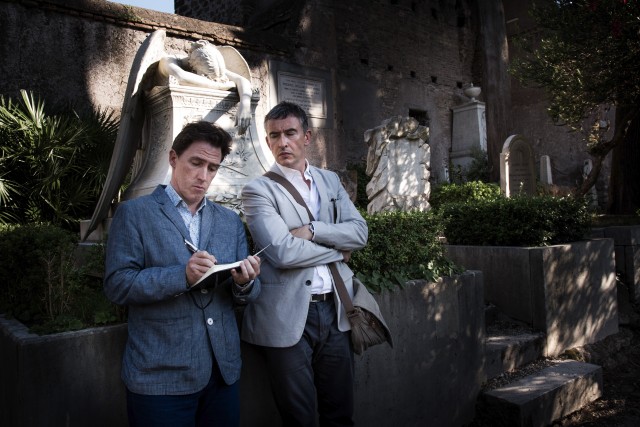 Steve Coogan looks on as Rob Brydon writes in a notebook in "The Trip to Italy."
