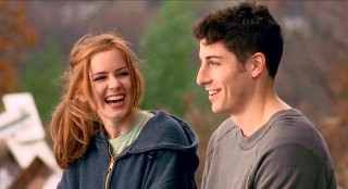 Katie and Anderson (Jason Biggs) share a laugh while sitting atop a hill of junk.