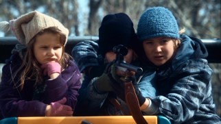 Ree (Jennifer Lawrence) teaches her younger brother and sister (Ashlee Thompson) how to shoot a gun, a skill that might come in handy should they want to eat.