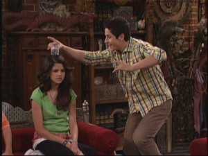 Justin (David Henrie) experiments with a time-freezing spell by balancing a cup of water on Alex's (Selena Gomez) head.