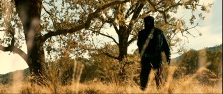 Marked only by a crosshairs graphic on his chest (the Zodiac emblem), our enigmatic serial killer approaches another couple on a pleasant day.