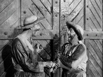 These two men -- let's call them Pancho (Frank Yaconelli) and Pepe (Nick Moro) -- are heartily amused by the sight of Zorro's Z on this set of doors.