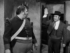 Bernardo (Gene Sheldon) waves to Sergeant Garcia (Henry Calvin) in an impromptu attempt to hide that he hears more than he lets on.