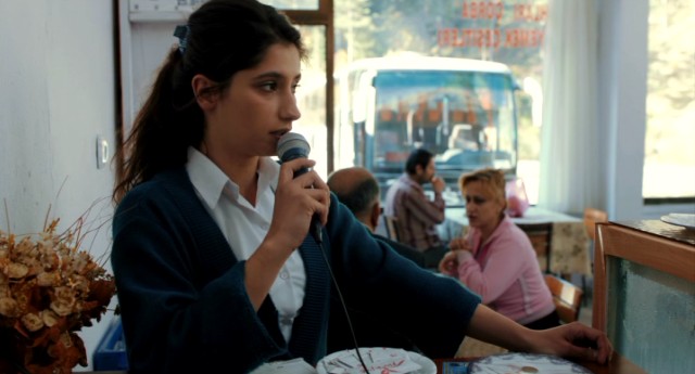 College dropout Seher (Nilay Erdonmez) informs those in the Tosya depot their bus will departing shortly in the Turkish film "Watchtower."