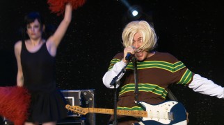 With cheerleaders cheering him on, Weird Al emulates the late Kurt Cobain in his parody "Smells Like Nirvana."