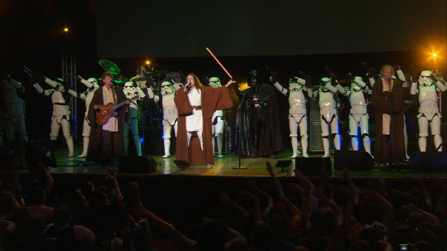 The Force is with Weird Al on "The Saga Begins", a number that finds him joined by stormtroopers, Jedi knights, and Darth Vader himself, while the audience waves their arms in rhythm.