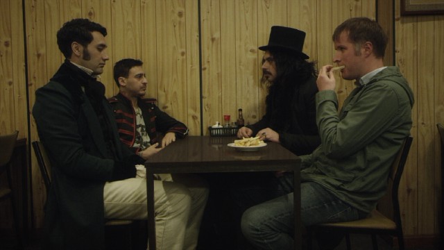 Three vampires (Taika Waititi, Cori Gonzalez-Macuer, and Jemaine Clement) join their new human friend Stu (Stu Rutherford), as he grabs a bite to eat in "What We Do in the Shadows."