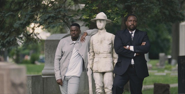Jatemme (Daniel Kaluuya) and Jamal Manning (Brian Tyree Henry) look on from a distance at the cemetery burial of Harry Rawlins.
