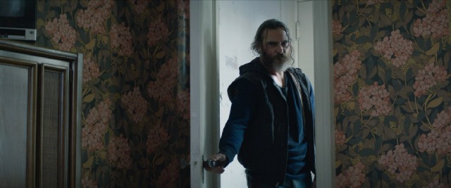 Joe (Joaquin Phoenix) takes a look inside a bedroom in "You Were Never Really Here."