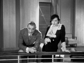 Baron von Gaigern (John Barrymore) and stenographer Flaemmchen (Joan Crawford) share a smoke and chat in one of Grand Hotel's expansive halls.