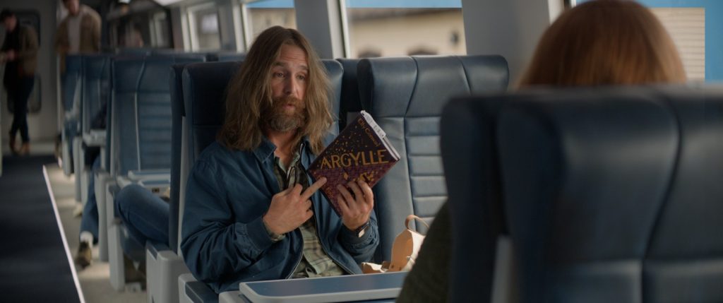Sam rockwell evokes zaphod beeblebrox in his first scene of "argylle" playing a fan/spy.