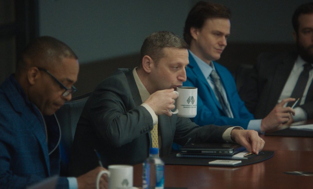 Friendship Blu-ray 7 Craig ships from a too-full coffee cup at a conference table work meeting.